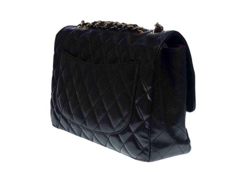 Chanel Classic Jumbo flap bag in black lambskin leather with gold hardware and quilted design.