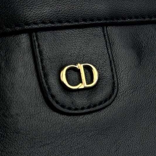 Detaljebillede af Christian Dior CD-logo i guld på sort læder skuldertaske
