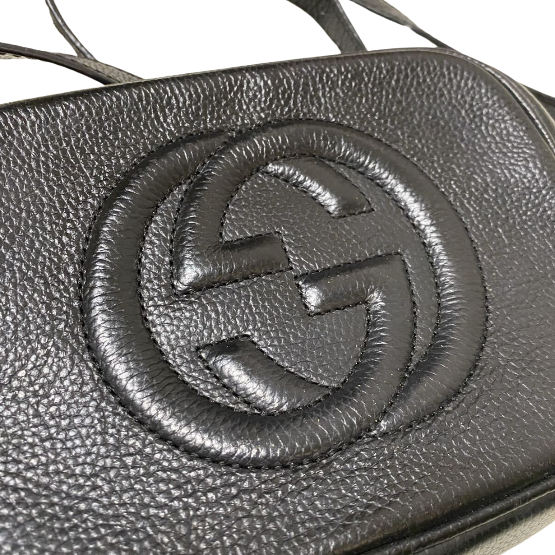 Close-up af præget GG-logo på Gucci Soho Small crossbody i læder
