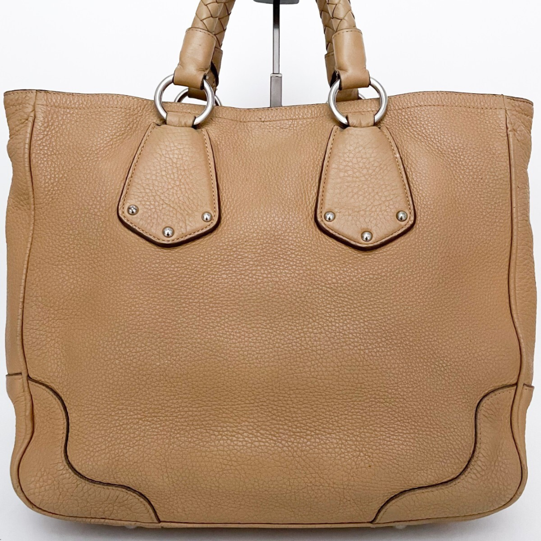 Bagside af Prada tote – struktureret beige læder og sølv hardware tæt på.