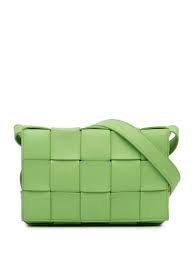 Bottega Veneta green woven leather bag with adjustable strap, showcasing luxury craftsmanship.