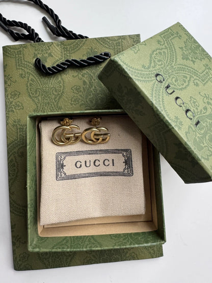 Autentiske Gucci GG Marmont øreringe i antikguld placeret i original Gucci æske og dustbag