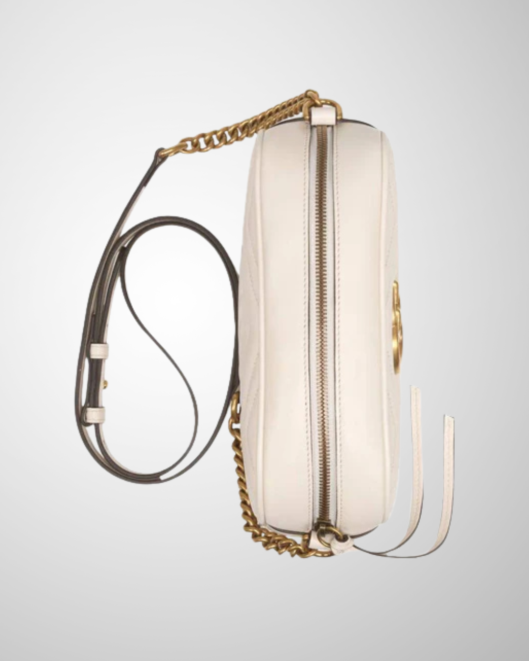 Mini Gucci Marmont Camera Taske set fra siden med quiltet off-white læder og guldfarvet kæde.