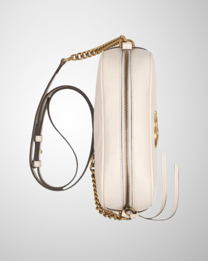 Mini Gucci Marmont Camera Taske set fra siden med quiltet off-white læder og guldfarvet kæde.