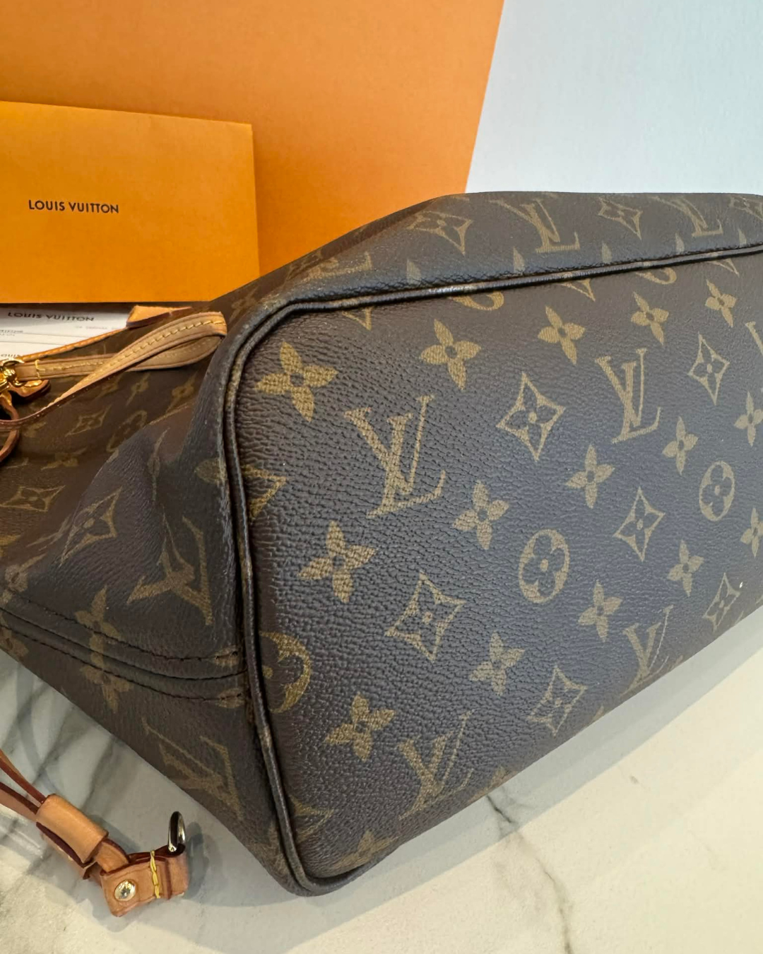 Close-up af bunden og monogram canvas på Louis Vuitton Neverfull MM